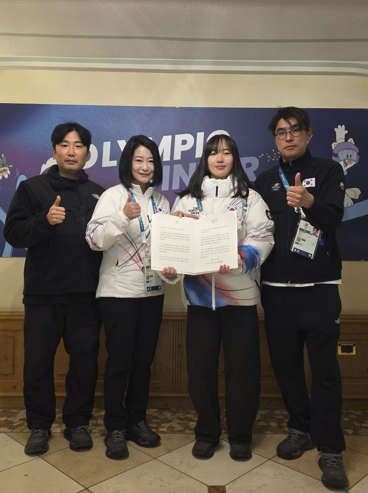 [밀라노=뉴시스] 김근수 기자 = 여자 스노보드 빅에어 동메달리스트 유승은이 10일(현지 시간) 이탈리아 밀라노에서 김나미 대한체육회 사무총장에게 이재명 대통령 축전을 받고 기념촬영을 하고 있다. 왼쪽부터 이창호 스노보드 슬로프스타일 및 빅에어 코치, 김나미 대한 체육회 사무총장, 유승은 선수, 김수철 스노보드 하프파이프 감독. (사진 = 대한체육회 제공) 2026.02.11. photo@newsis.com *재판매 및 DB 금지