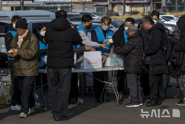 [서울=뉴시스] 정병혁 기자 = 염영남 뉴시스 대표이사 사장과 임직원들로 구성된 뉴시스 봉사단이 11일 서울 용산구 서울역 광장에서 노숙인 설맞이 떡 나눔 지원 봉사활동을 하고 있다. 2026.02.11. jhope@newsis.com