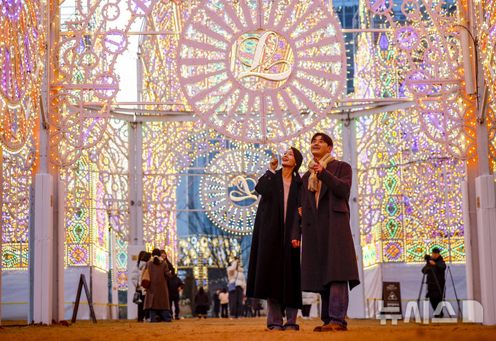 [서울=뉴시스] 정병혁 기자 = 11일 서울 송파구 롯데월드타워 월드파크 일대에서 열린 2026 롯데 루미나리에에서 모델들 포즈를 취하고 있다. 2026.02.11. jhope@newsis.com