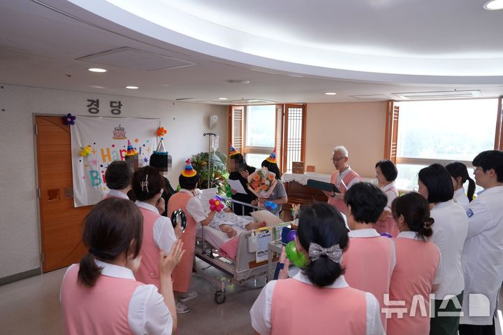 [서울=뉴시스] 의료진과 자원봉사자가 함께 축하하는 서울성모병원 호스피스병동 완화의료 프로그램 중 하나인 생신잔치 이벤트. (사진= 서울성모병원 제공)