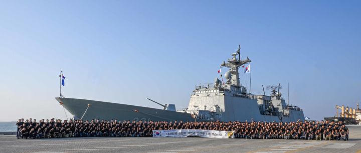 [부산=뉴시스] 청해부대 46진 전 부대원이 오만 두큼항에 정박해 파병함인 최영함(충무공이순신급 구축함·DDH-Ⅱ·4400t급) 앞에서 기념사진을 찍고 있다. (사진=해군작전사 제공) 2026.02.12. photo@newsis.com *재판매 및 DB 금지