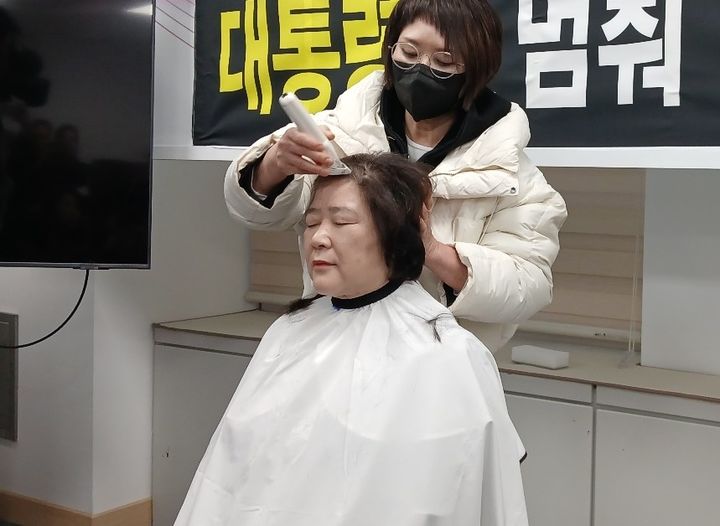 [대전=뉴시스] 조명휘 기자 = 안경자(국민의힘·비례) 대전시의원이 12일 대전시의회 기자실에서 대통령이 대전충남행정통합을 멈춰세워달라고 요구하며 삭발을 하고 있다. 2026.02.12. joemedia@newsis.com *재판매 및 DB 금지