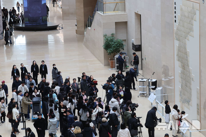 [서울=뉴시스] 권창회 기자 = 12일 오전 서울 용산구 국립중앙박물관에서 열린 '역사의 길 대동여지도를 펼치다' 개막행사에서 관람객들이 대동여지도 영인본을 살펴보고 있다. 2026.02.12. kch0523@newsis.com