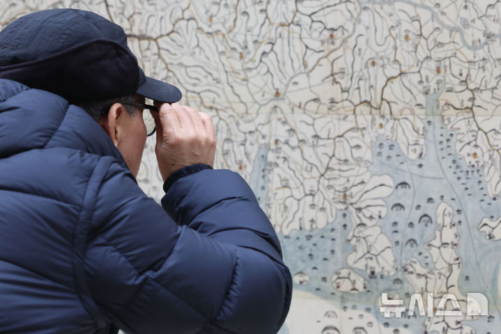 [서울=뉴시스] 권창회 기자 = 12일 오전 서울 용산구 국립중앙박물관에서 열린 '역사의 길 대동여지도를 펼치다' 개막행사에서 관람객들이 대동여지도 영인본을 살펴보고 있다. 2026.02.12. kch0523@newsis.com