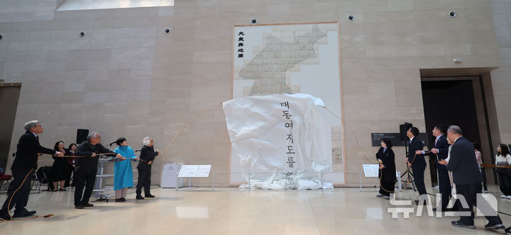 [서울=뉴시스] 권창회 기자 = 유홍준 국립중앙박물관장을 비롯한 참석자들이 12일 오전 서울 용산구 국립중앙박물관에서 열린 '역사의 길 대동여지도를 펼치다‘ 개막행사에서 대동여지도 영인본을 공개하고 있다. 2026.02.12. kch0523@newsis.com