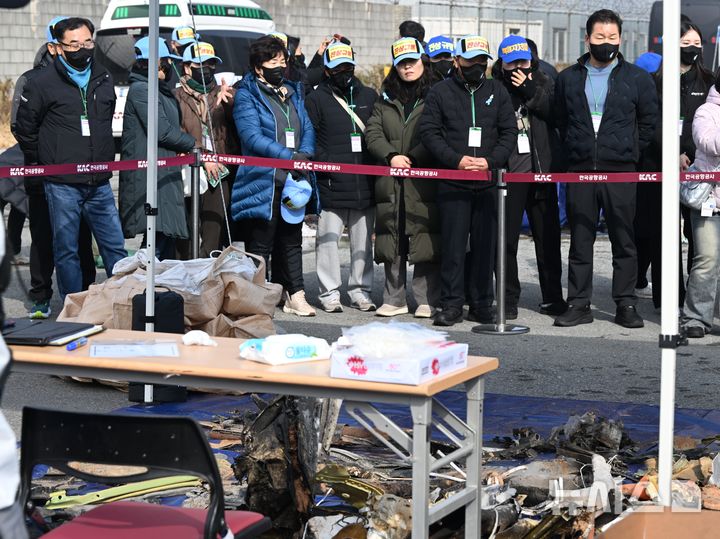 [무안=뉴시스] 이현행 기자 = 12·29무안공항 제주항공 참사 유가족 협의회가 12일 오전 전남 무안 국제공항에서 1년 넘게 방치돼 있던 여객기 잔해물을 바라보고 있다. 2026.02.12. lhh@newsis.com