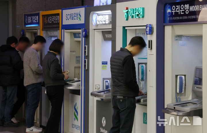[서울=뉴시스] 조성우 기자 = 인터넷전문은행의 수수료 지원금을 노려 하루에 최소 50여회, 최대 600여회나 현금을 반복 인출한 혐의를 받는 결제대행업체(VAN) 기기 가맹점주들에게 벌금형이 확정됐다. 사진은 서울 시내의 한 건물에서 시민들이 시중은행 ATM기기를 이용하는 모습. 2026.03.18. xconfind@newsis.com *사진은 기사 내용과 무관함.