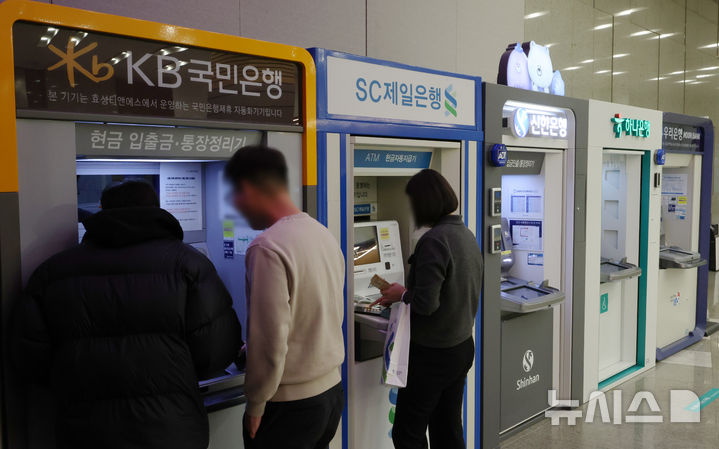 [서울=뉴시스] 조성우 기자 = 12일 서울 시내의 한 건물에서 시민들이 시중은행 ATM기기를 이용하고 있다. KB·신한·하나·우리·NH농협 등 5대 금융그룹은 지난해 당기순이익 20조 4700억 원을 기록하며 사상 처음으로 '20조 원 시대'를 열었다. 이는 전년(18조 8742억 원) 대비 1조 5958억 원(8.45%) 증가한 규모다. 2026.02.12. xconfind@newsis.com