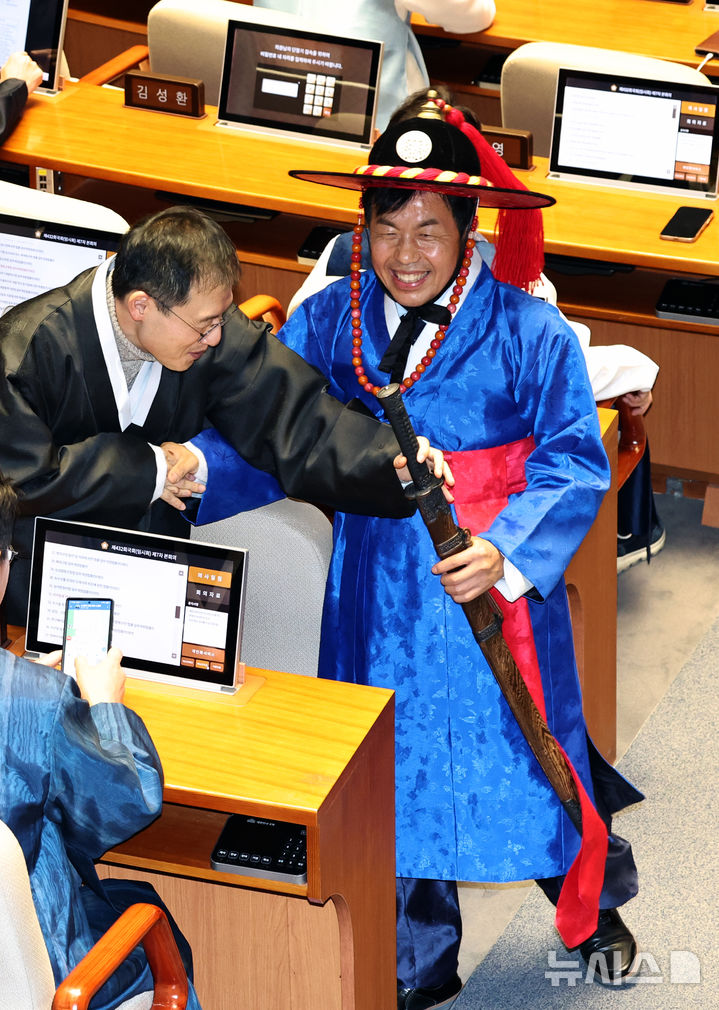 [서울=뉴시스] 김금보 기자 = 윤종오 진보당 의원이 12일 오후 서울 여의도 국회에서 열린 제432회국회(임시회) 제6차 본회의에서 포졸 한복을 입고 의원들과 촬영하고 있다. 2026.02.12. kgb@newsis.com