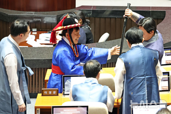 [서울=뉴시스] 김금보 기자 = 윤종오 진보당 의원이 12일 오후 서울 여의도 국회에서 열린 제432회국회(임시회) 제6차 본회의에서 포졸 한복을 입고 의원들과 촬영하고 있다. 2026.02.12. kgb@newsis.com