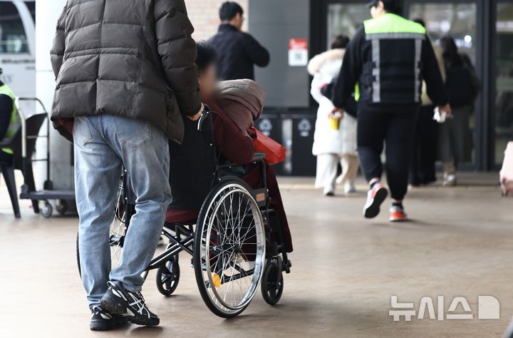 [서울=뉴시스] 2월 12일 서울 서초구 서울고속버스터미널에서 한 시민이 어머니의 휠체어를 밀고 이동하는 모습. 2026.02.12. kmn@newsis.com
