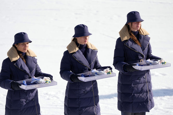 [테세로=AP/뉴시스] 12일(현지 시간) 이탈리아 테세로 크로스컨트리 스타디움에서 열린 2026 밀라노·코르티나담페초 동계 올림픽 크로스컨트리 스키 여자 10km 인터벌 프리 종목 시상식에서 관계자들이 메달과 마스코트를 들고 있다. 2026.02.14.