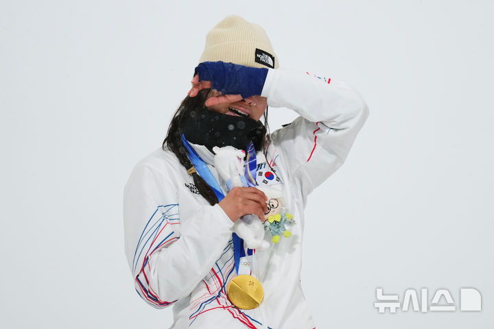 [리비뇨=AP/뉴시스] 최가온이 12일(현지 시간) 이탈리아 리비뇨 스노파크에서 열린 2026 밀라노·코르티나담페초 동계올림픽 스노보드 여자 하프파이프 결승에서 금메달을 획득한 뒤 눈물을 훔치고 있다. 2026.02.13.