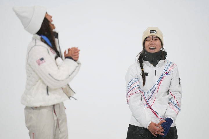 [리비뇨=AP/뉴시스] 최가온(오른쪽)이 12일(현지 시간) 이탈리아 리비뇨 스노파크에서 열린 2026 밀라노·코르티나담페초 동계올림픽 스노보드 여자 하프파이프 정상에 올라 금메달을 목에 걸고 웃음 짓고 있다. 최가온은 1차 시기에서 크게 넘어져 충격을 안겼으나 3차 시기에서 90.25점을 획득해 강력한 우승 후보 클로이 김(미국, 왼쪽)을 제치고 정상에 올랐다. 최연소 금메달 기록도 갈아치운 그는 시상식 도중 애국가가 흘러나오자, 끝내 눈물을 흘렸다. 2026.02.13.