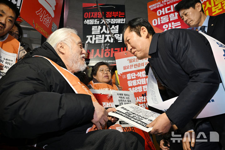 [서울=뉴시스] 김금보 기자= 정청래 더불어민주당 대표가 13일 서울 용산역에 귀성 인사차 방문해 박경석 전국장애인차별철폐연대(전장연) 대표를 만나 '색동원 문제해결 및 지역사회에서 함께 살 권리를 위한 면담 요구안'을 전달 받고 있다.(공동취재) 2026.02.13. photo@newsis.com
