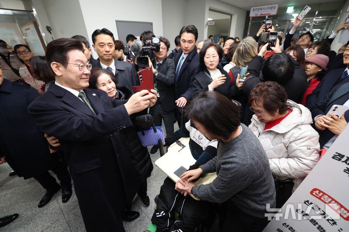 [충주=뉴시스] 최동준 기자 = 이재명 대통령이 11일 충북 충주시건강복지타운 내 취약계층이 무료로 라면을 먹을 수 있는 공유 공간인 '나누면'을 방문해 운영 현황을 점검한 뒤 시민들과 셀카를 찍고 있다. 2026.02.11. photocdj@newsis.com