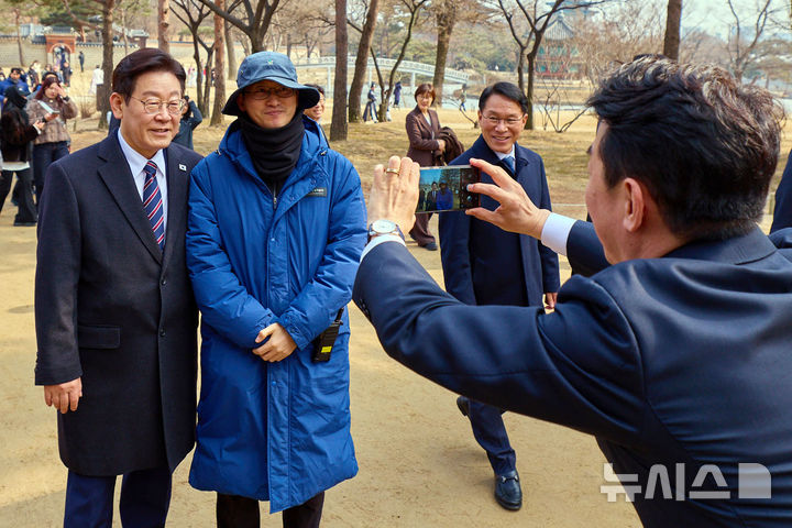 [서울=뉴시스] 최동준 기자 = 이재명 대통령이 12일 서울 종로구 경복궁에서 참모진과 산책을 하며 시민들과 기념 사진을 찍고 있다. (사진=청와대 제공) 2026.02.12. photo@newsis.com *재판매 및 DB 금지