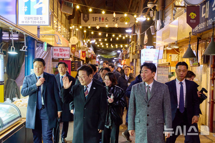 [서울=뉴시스] 최동준 기자 = 이재명 대통령이 9일 서울 종로구 통인시장을 방문해 상인들과 인사하고 있다. 이번 일정은 최근 일부 경제지표가 개선되는 흐름을 보이고 있지만 장바구니 물가 등 체감경기가 여전히 어렵다는 국민들의 목소리를 현장에서 직접 듣기 위해 마련됐다. (사진=청와대 제공) 2026.02.09. photo@newsis.com *재판매 및 DB 금지