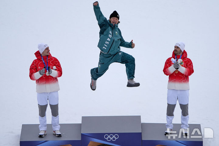 [보르미오=AP/뉴시스] 루카스 피녜이루 브라던(브라질·가운데)이 14일(현지 시간) 이탈리아 보르미오의 스텔비오 스키 센터에서 열린 2026 밀라노·코르티나담페초 동계올림픽 알파인 스키 남자 대회전 경기 금메달을 획득한 뒤 시상대에 올라 기뻐하고 있다. 2026.02.14.