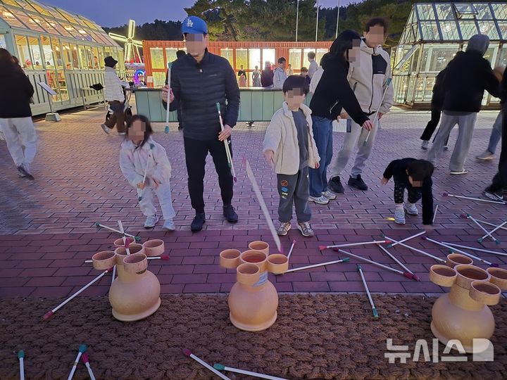 [울산=뉴시스] 구미현 기자 = 설 연휴 첫날인 13일 저녁 울산대공원을 찾은 방문객들이 전통놀이를 체험하고 있다. 2026.02.13. photo@newsis.com