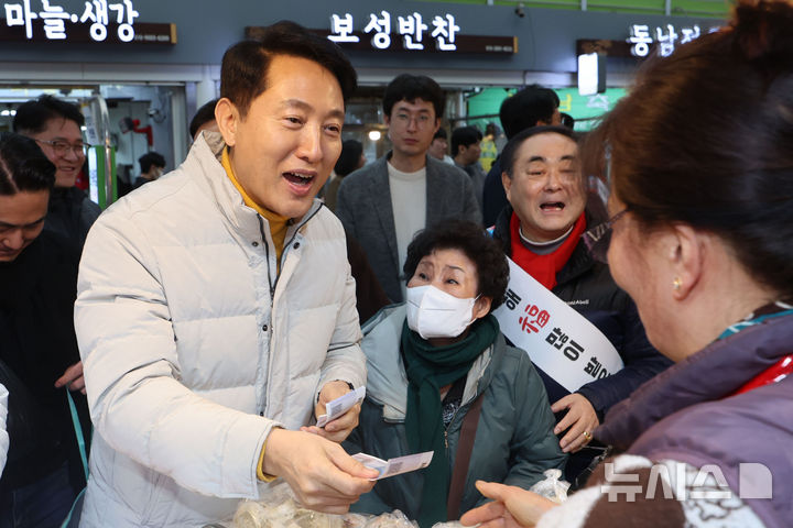 [서울=뉴시스] 권창회 기자 = 오세훈 서울시장이 14일 서울 영등포구 영등포 전통시장을 방문해 설 명절 물가점검 겸 떡과 만두를 구매하고 있다. 2026.02.14. kch0523@newsis.com