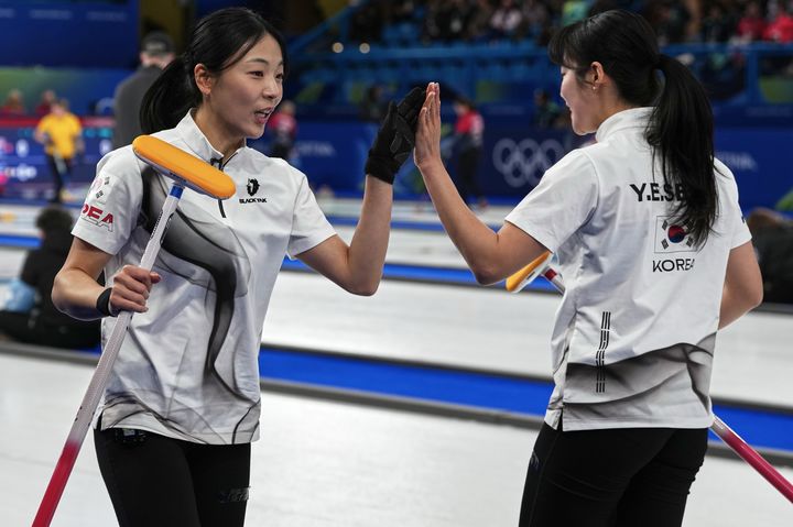 [코르티나담페초=AP/뉴시스] 한국 여자 컬링 대표팀(경기도청) 김민지와 설예은이 15일(현지 시간) 이탈리아 코르티나담페초의 코르티나 컬링 올림픽 스타디움에서 열린 2026 밀라노·코르티나 동계올림픽 컬링 라운드로빈 5차전 일본과 경기 중 하이파이브를 하고 있다. 한국이 7-5로 승리해 3승2패를 기록했다. 2026.02.16.