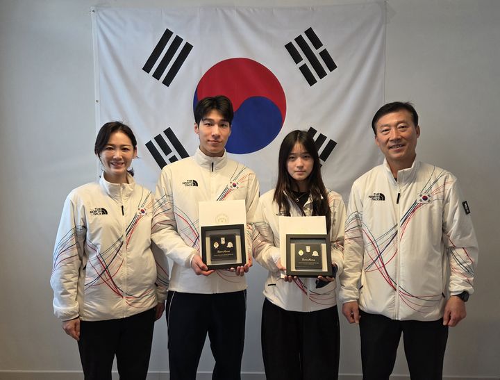 [서울=뉴시스] 최가온과 황대헌이 15일(한국 시간) 이탈리아 밀라노 선수촌에서 이수경 한국 선수단장, 김택수 국가대표 선수촌장을 통해 이재명 대통령의 축전을 전달받았다. (사진 = 대한체육회 제공) *재판매 및 DB 금지