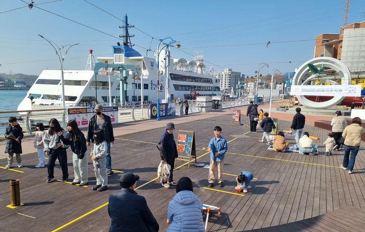[울산=뉴시스] 박수지 기자 = 16일 오전 울산 남구 장생포에 마련된 '민속놀이 한마당' 행사장에서 가족단위 방문객들이 체험을 즐기고 있다. 2026.02.16. parksj@newsis.com *재판매 및 DB 금지