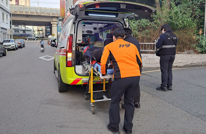 [부산=뉴시스] 15일 오후 부산 부산진구 범천동의 한 길에 쓰러져 있던 80대가 병원으로 이송되고 있다. (사진=부산 부산진경찰서 제공) 2026.02.16 photo@newsis.com *재판매 및 DB 금지