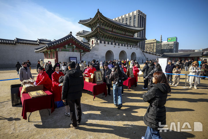 [서울=뉴시스] 정병혁 기자 = 16일 서울 종로구 경복궁 흥례문 광장에서 열린 2026년 병오년 수문장 세화 나눔행사에서 시민들이 세화를 받고 있다. 2026.02.16. jhope@newsis.com