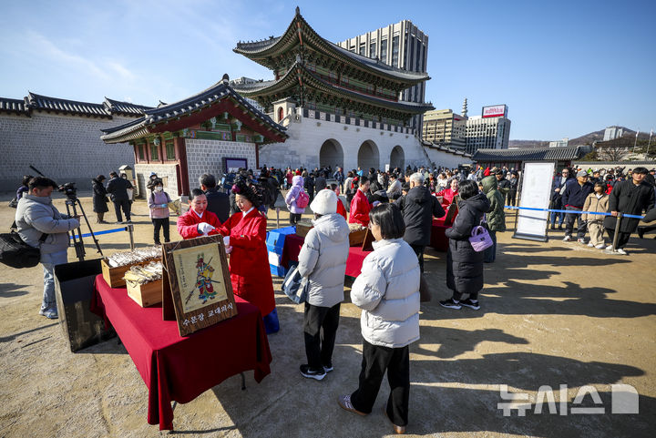 [서울=뉴시스] 정병혁 기자 = 16일 서울 종로구 경복궁 흥례문 광장에서 열린 2026년 병오년 수문장 세화 나눔행사에서 시민들이 세화를 받고 있다. 2026.02.16. jhope@newsis.com