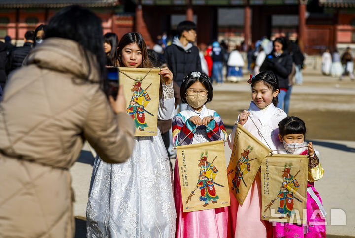 [서울=뉴시스] 정병혁 기자 = 16일 서울 종로구 경복궁 흥례문 광장에서 열린 2026년 병오년 수문장 세화 나눔행사에서 시민들이 세화를 받은 뒤 사진을 찍고 있다. 2026.02.16. jhope@newsis.com