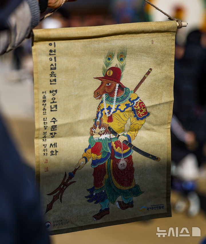 [서울=뉴시스] 정병혁 기자 = 16일 서울 종로구 경복궁 흥례문 광장에서 열린 2026년 병오년 수문장 세화 나눔행사에서 시민들이 세화를 받은 뒤 사진을 찍고 있다. 2026.02.16. jhope@newsis.com