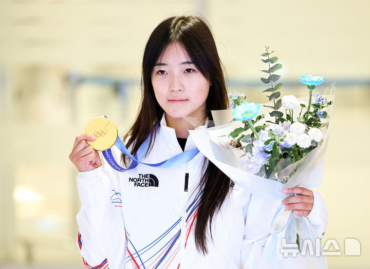 [인천공항=뉴시스] 최진석 기자 = 2026 밀라노·코르티나담페초 동계 올림픽 스노보드 여자 하프파이프 금메달을 획득한 최가온이 16일 인천국제공항 제2여객터미널을 통해 귀국해 금메달을 들어 보이고 있다. 최가온은 한국 설상 종목 1호 금메달리스트가 됐다. 이는 이번 대회에서 수확한 한국 선수단의 첫 금메달이다. 2026.02.16. myjs@newsis.com