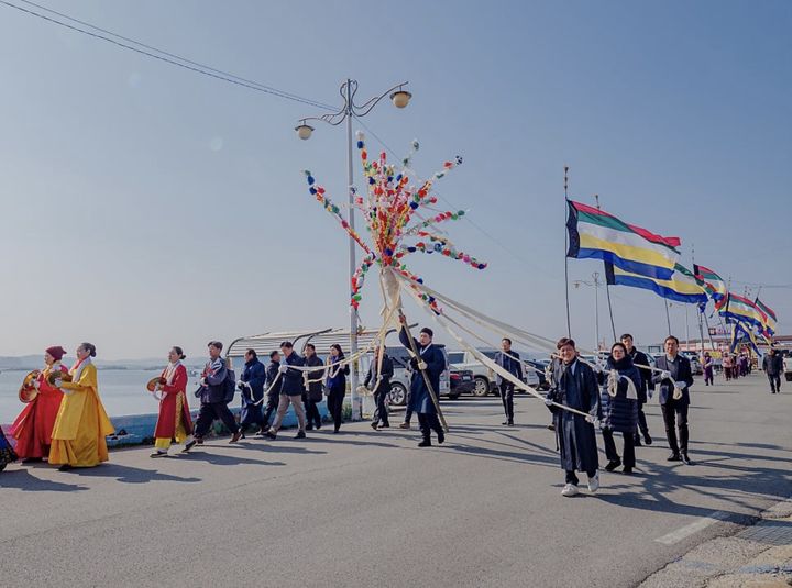 [서산=뉴시스] 지난 2024년 충남 서산시 부석면 창리 일원에서 열린 영신풍어제에 참가한 마을 주민들이 선착장에서 깃발을 들고 영신당으로 가고 있다. (사진=창리어촌계 제공) 2026.02.18. photo@newsis.com *재판매 및 DB 금지