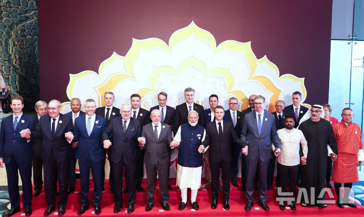 [뉴델리=AP/뉴시스] 19일 인도 뉴델리에서 열리고 있는 제4회 인공지능(AI) 임팩트 정상회의 참석자들이 손을 맞잡고 기념촬영하고 있다. 앞줄 중앙에 브라질 루이스 이나시우 룰라 다 시우바 대통령, 나렌트라 모디 인도 총리, 에마뉘엘 마크롱 프랑스 대통령 등이 서있다.2026.02.19