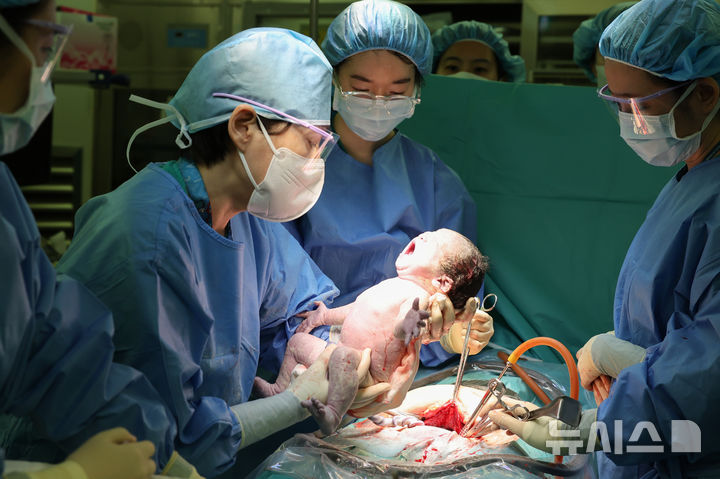 [서울=뉴시스] 원혜성 서울아산병원 산부인과 교수(왼쪽 두 번째)가 월 300번째 분만 수술을 시행하고 있다. (사진= 서울아산병원 제공)