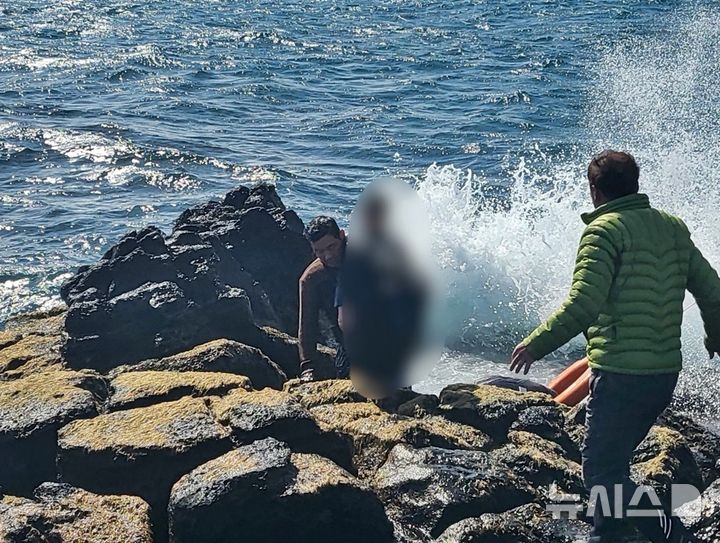 [제주=뉴시스] 19일 오후 제주 서귀포시 마라도 신작로 소재 해안가에서 마라도의용소방대가 물에 빠진 10대와 50대 부자를 구조하고 있다. (사진=제주소방안전본부 제공) 2026.02.19. photo@newsis.com