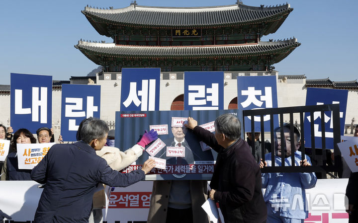 [서울=뉴시스] 김혜진 기자 = 전국민중행동 회원들이 19일 서울 종로구 광화문 월대 앞에서 내란수괴 윤석열 엄중처벌 촉구 기자회견을 열고 규탄 퍼포먼스를 하고 있다. 2026.02.19. jini@newsis.com