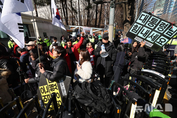 [서울=뉴시스] 배훈식 기자 = 윤석열 전 대통령의 내란 우두머리 혐의에 대한 1심 선고일인 19일 오후 서울 서초구 중앙지방법원 앞으로 윤 전 대통령을 태운 호송차가 들어가자 지지자들이 환호하고 있다. 2026.02.19. dahora83@newsis.com