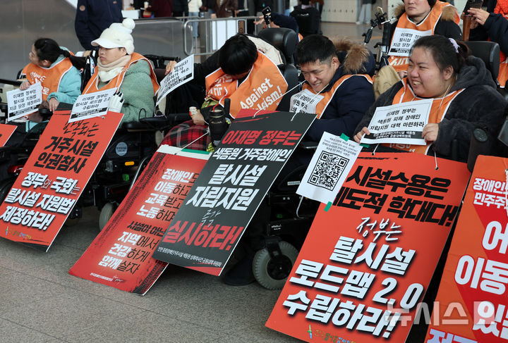 전국장애인차별철폐연대(전장연) 회원들이 19일 오후 서울 용산구 서울역 대합실 농성장 앞에서 장애인권리보장법 및 장애인탈시설지원법 제정 촉구 결의대회를 하고 있다. 2026.02.19. 20hwan@newsis.com