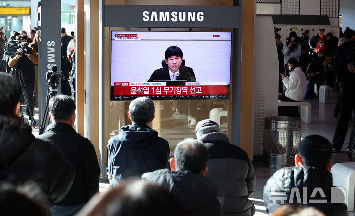 [서울=뉴시스] 이영환 기자 = 19일 오후 서울 용산구 서울역에서 시민들이 '내란 우두머리 혐의' 윤석열 전 대통령의 1심 선고 공판 중계를 시청하고 있다. 윤 전 대통령은 1심에서 무기징역을 선고 받았다. 2026.02.19. 20hwan@newsis.com