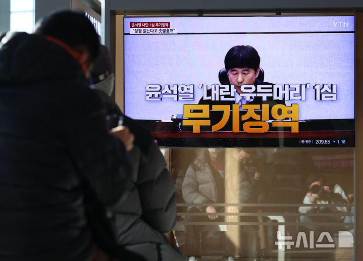 [서울=뉴시스] 이영환 기자 = 19일 오후 서울 용산구 서울역에서 시민들이 '내란 우두머리 혐의' 윤석열 전 대통령의 1심 선고 공판 중계를 시청하고 있다.&nbsp; 윤 전 대통령은 1심에서 무기징역을 선고 받았다. 2026.02.19. 20hwan@newsis.com