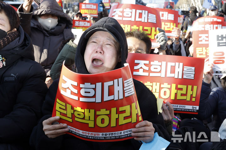 [서울=뉴시스] 김혜진 기자 = 윤석열 전 대통령의 내란 우두머리 혐의에 대한 1심 선고가 내려진 19일 서울중앙지법 인근에서 촛불행동 관계자들이 눈물을 흘리고 있다. 2026.02.19. jini@newsis.com