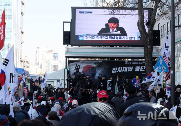 [서울=뉴시스] 배훈식 기자 = 윤석열 전 대통령의 내란 우두머리 혐의에 대한 1심 선고일인 19일 오후 서울 서초구 중앙지방법원 주변에서 윤 전 대통령 지지자들이 재판 생중계를 보고 있다. 2026.02.19. dahora83@newsis.com