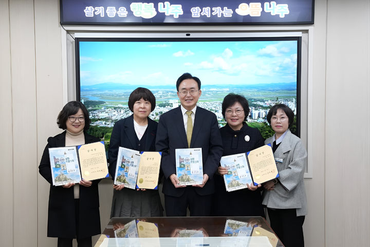 윤병태 전남 나주시장(가운데)이 1851년(철종 2년) 당시 프랑스 포경선 '나르발호 표류 사건'을 수록한 프랑스 고교 역사교과서를 펼쳐 보이고 있다. (사진=윤병태 나주시장 페이스북 갈무리) photo@newsis.com *재판매 및 DB 금지