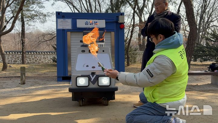 [서울=뉴시스] 한이재 기자 = 20일 오전 10시30분께 서울 종로구에 있는 창덕궁 영화당 앞에서 열린 순찰로봇 '순라봇' 시연회에서 관계자가 화재 테스트를 하고 있다. 2026.02.20. nowone@newsis.com