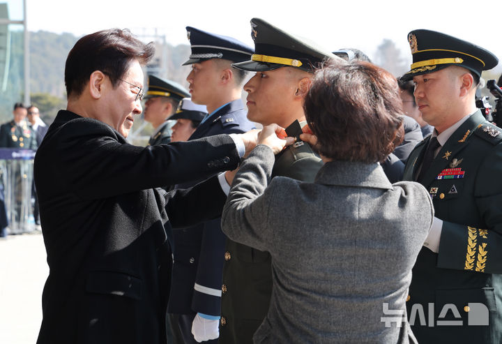 [계룡=뉴시스] 최동준 기자 = 이재명 대통령이 20일 충남 계룡대 대연병장에서 열린 육·해·공군 사관학교 통합임관식에서 임관 장교들에게 계급장을 달아주고 있다. (청와대통신사진기자단) 2026.02.20. photocdj@newsis.com