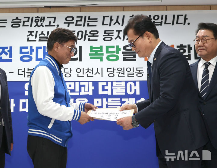 [인천=뉴시스] 전진환 기자 = 송영길(오른쪽) 전 더불어민주당 대표가 20일 인천 남동구 더불어민주당 인천시당을 찾아 고남석 시당위원장에게 복당 신청서를 제출하고 있다. 송영길 전 대표는 더불어민주당 전당대회 ‘돈봉투 살포’ 의혹 등으로 기소돼 항소심에서 무죄를 선고받았다. 2026.02.20. amin2@newsis.com