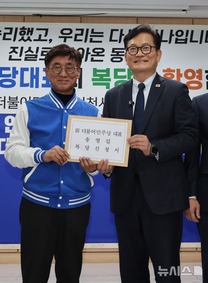 [인천=뉴시스] 전진환 기자 = 송영길 전 더불어민주당 대표가 20일 인천 남동구 더불어민주당 인천시당을 찾아 고남석 시당위원장에게 복당 신청서를 제출하고 있다. 송영길 전 대표는 더불어민주당 전당대회 ‘돈봉투 살포’ 의혹 등으로 기소돼 항소심에서 무죄를 선고받았다. 2026.02.20. amin2@newsis.com
